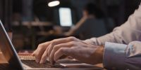 Extreme close-up of hands typing on a laptop computer.